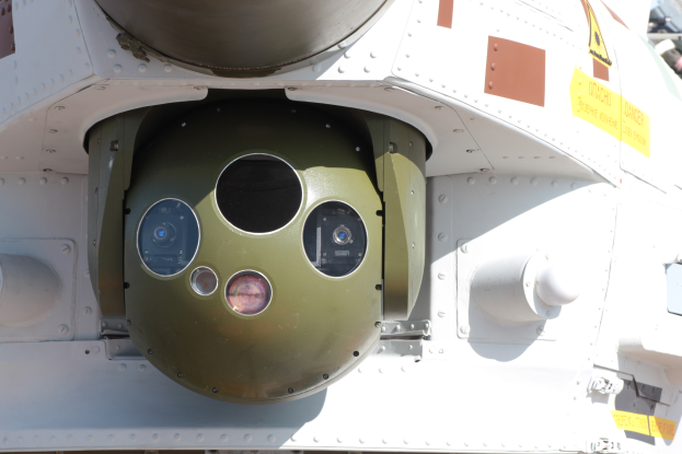 Nahaufnahme eines Militärfahrzeugs mit einer grün-weißen runden Rakete an der Seite in einem Metallrahmen.