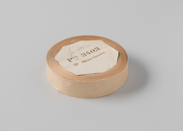 Brune Papiertapetenrolle mit handgeschriebener Beschriftung auf einem weißen Hintergrund.