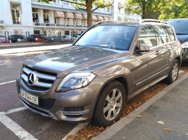 Ein Mercedes-Benz GLK 350 CDI BlueEfficiency Avantgarde auf einer Straße mit Bäumen und Gebäuden mit Fenstern im Hintergrund.