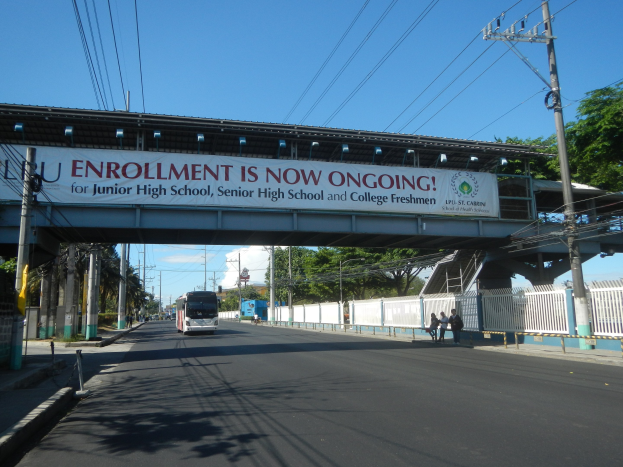 Ein Bus fährt unter einer Brücke mit einem Schild "Anmeldung läuft"