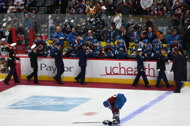 Eishockeyspieler auf dem Eis umgeben von Teamkollegen und Zuschauern während eines Spiels von Colorado Avalanche gegen San Jose Sharks am 24. März 2015.
