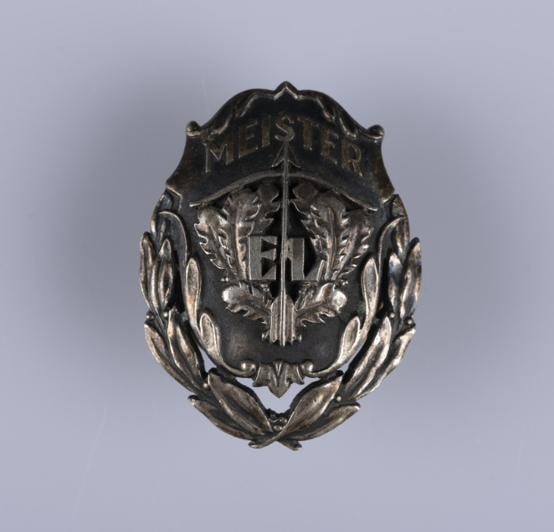 Ein silbernes Abzeichen mit einem Lorbeerkranz, das die deutsche Armee darstellt, mit Text in der Mitte.