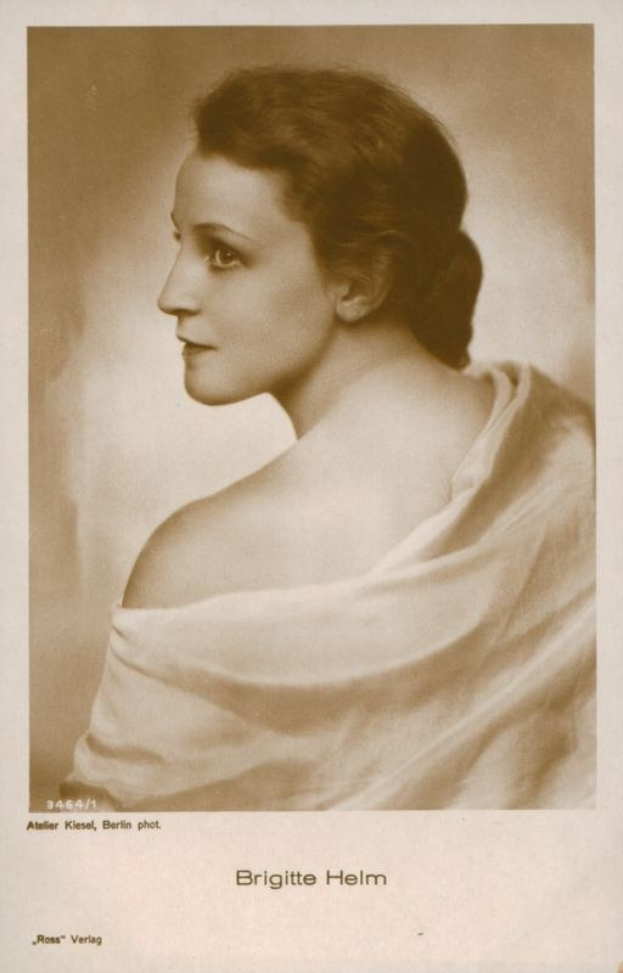 Schwarzes und weißes Porträt der deutschen Schauspielerin Brigitte Helm in einem weißen Kleid mit Text unten.