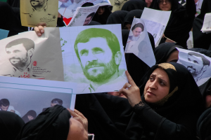 Eine Gruppe iranischer Frauen in schwarzer Kleidung, einige mit Brille, halten Fotos von Präsident Mahmoud Ahmadinejad während einer Demonstration in Tehran.